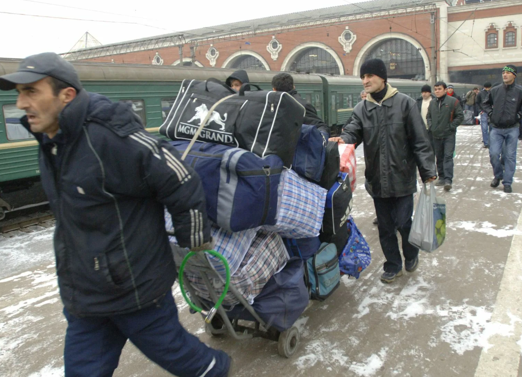 Приезжий остановился. Трудовые мигранты. Гастарбайтеры едут в Россию. Эмигранты в Москве. Мигранты в России.